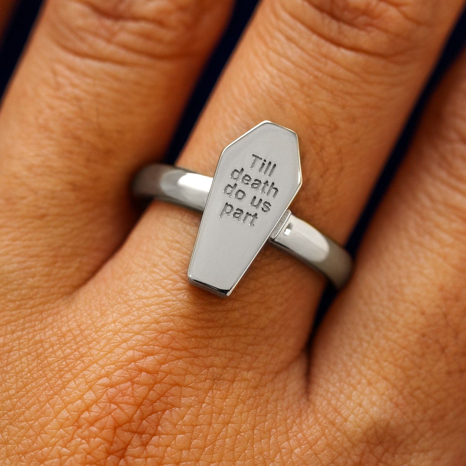 Close up view of a model's hand wearing a white gold Coffin Ring in the closed position