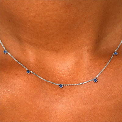 Close up view of a model's neck wearing a solid 14k white gold 5 Gemstone Cable Necklace in sapphire