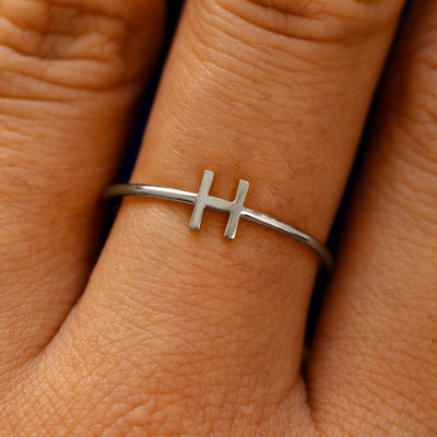 Close up view of a model's fingers wearing a 14k white gold block initial Ring with the letter H