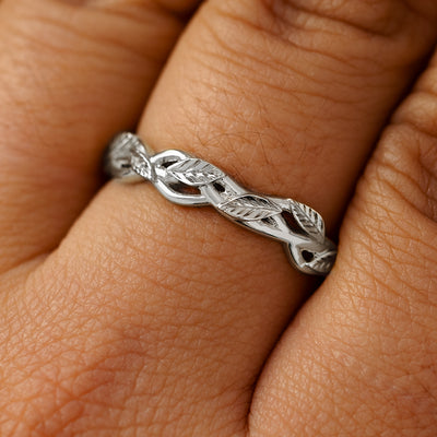 A solid 14k white gold braided leaves and vines ring on a model's finger