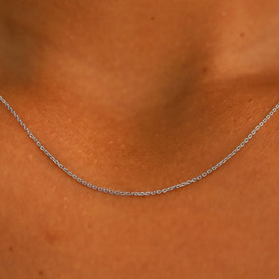 14k white gold Gold cable chain  necklace on a person's neck with a close-up focus on the jewelry.