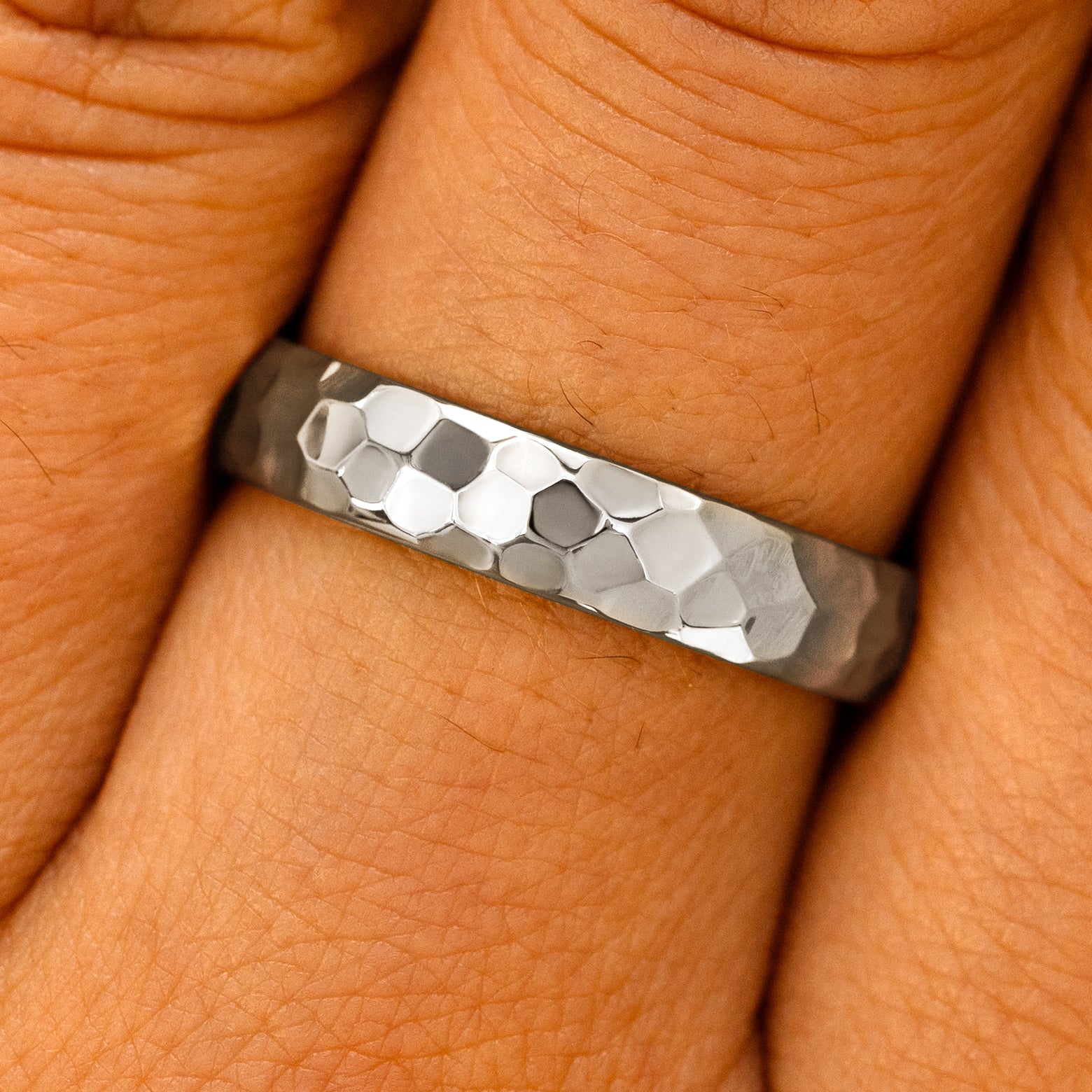 Close up view of a model's fingers wearing a 14k White Gold Curvy Hammered Band