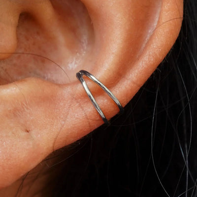 Close up view of a model's ear wearing a white gold Double Cuff