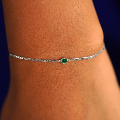 A model's wrist wearing a 14 karat white gold Emerald Bracelet