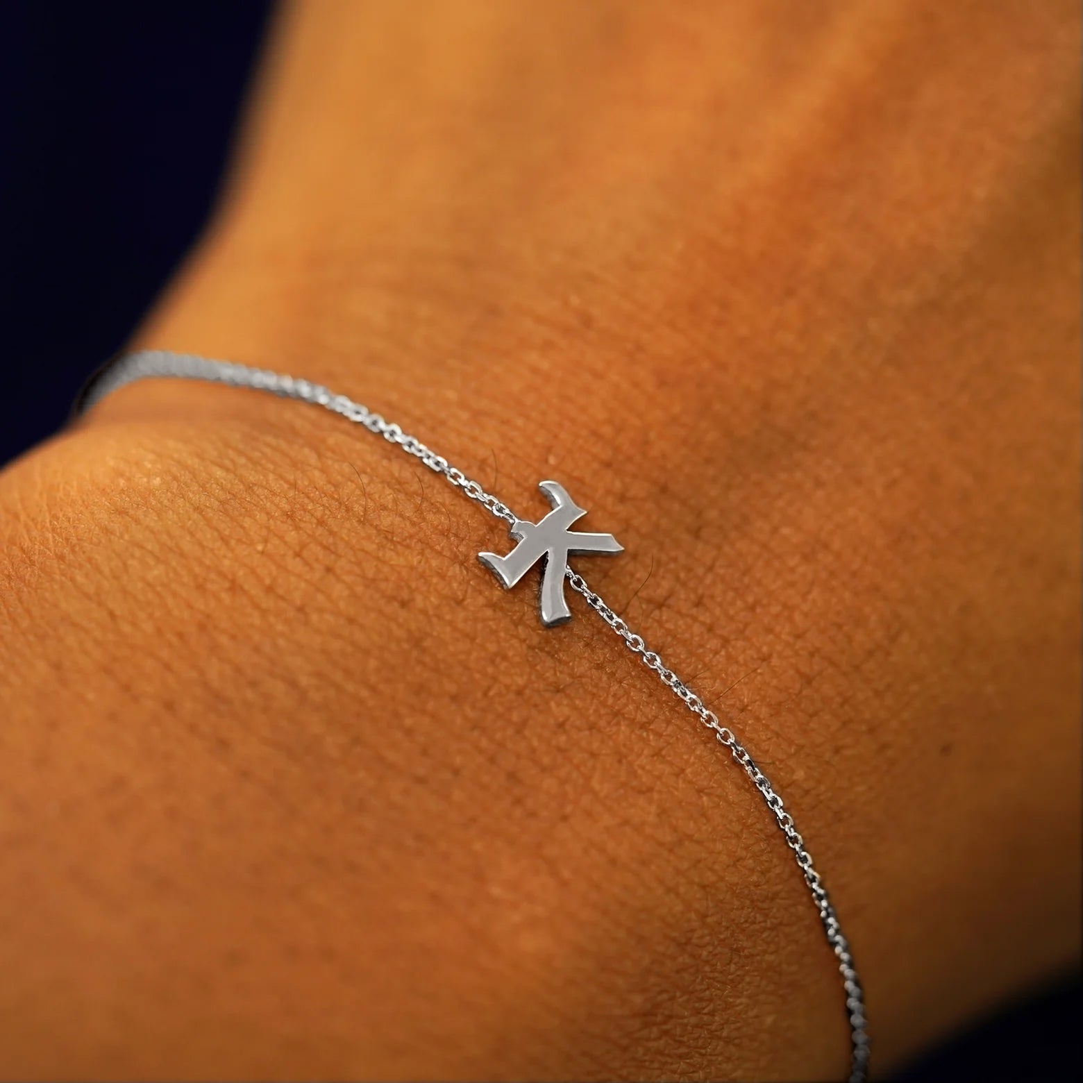 A model's wrist wearing a 14k solid white gold Initial Bracelet in the letter K