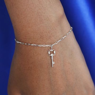 Close up view of a model's wrist wearing a white gold Key Charm on a Butch Bracelet
