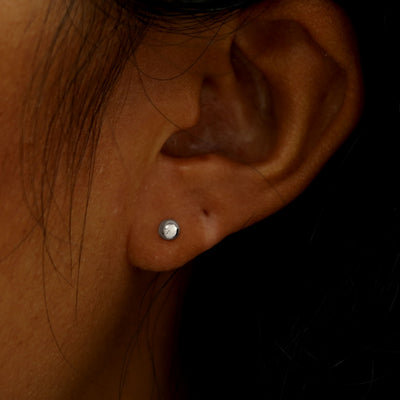 Close up view of a model's ear wearing a white gold Medium Ball Earring