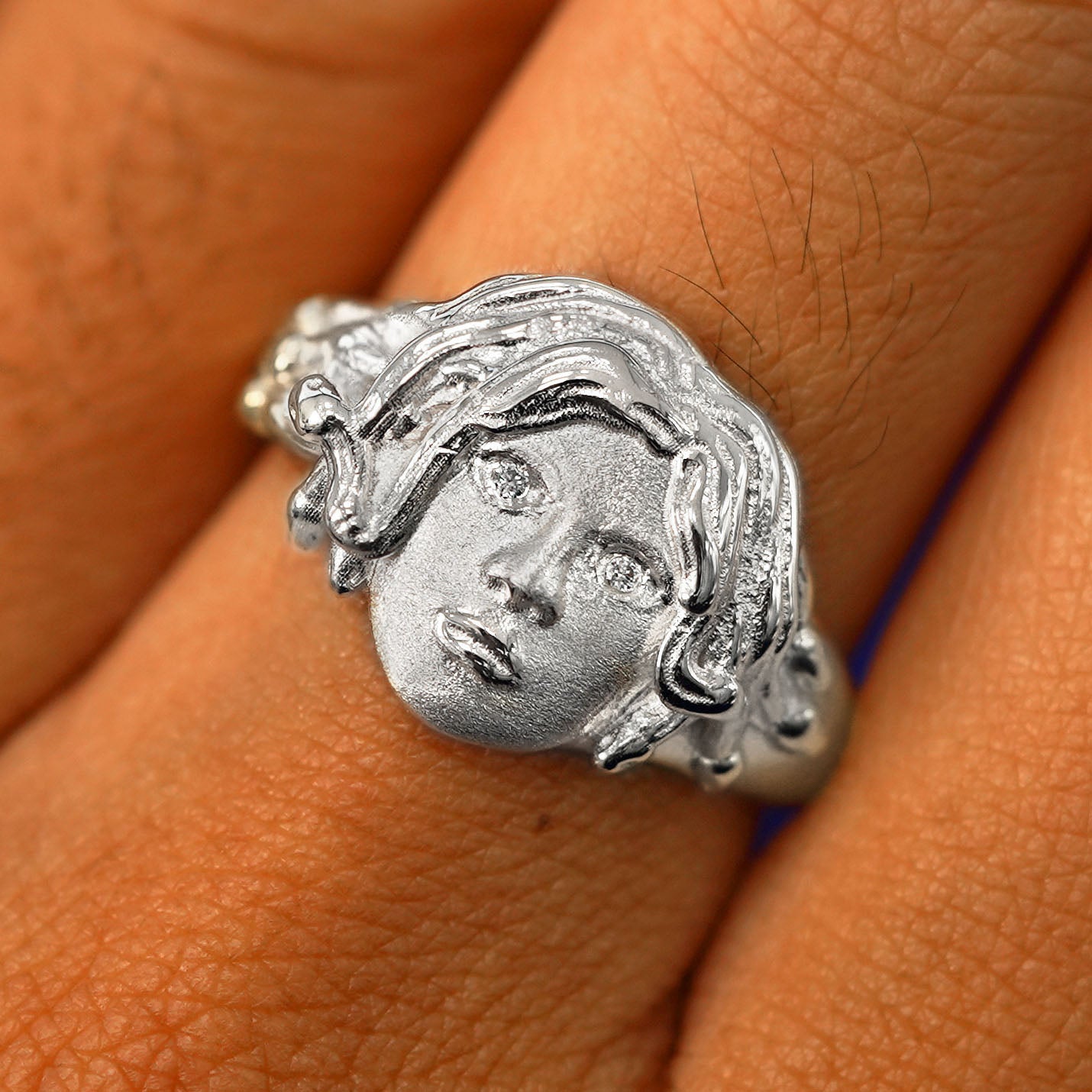 Close up view of a model's fingers wearing a 14k white gold Medusa Ring