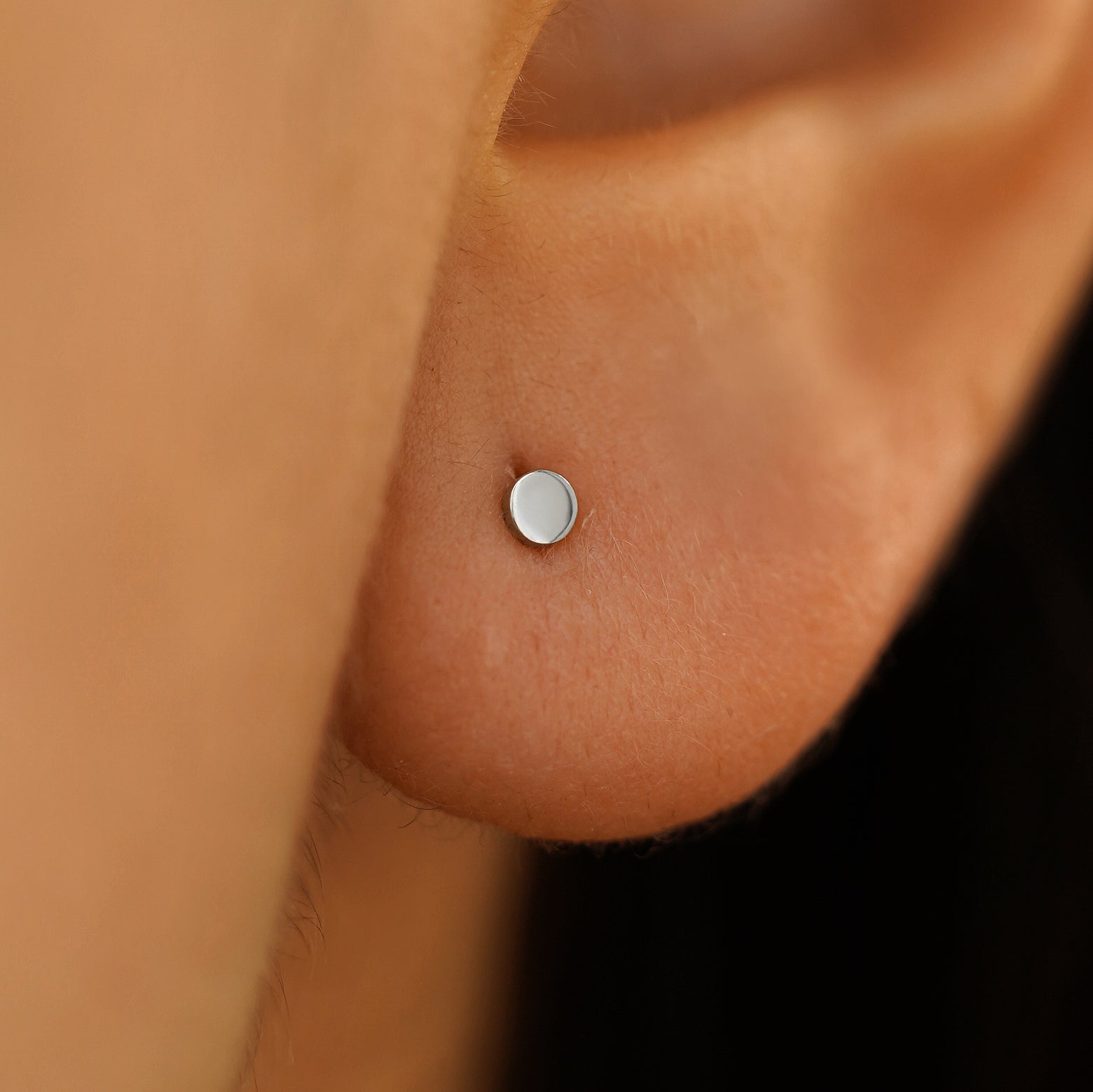 Close up view of mini circle earring on a model's ear