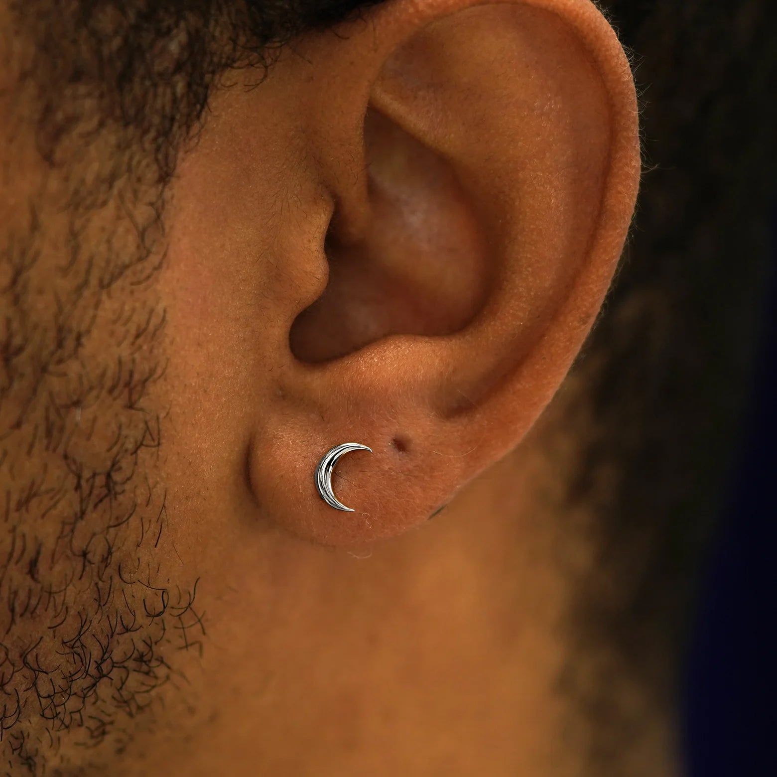 Close up view of a model's ear wearing a  14k white gold Moon Earring