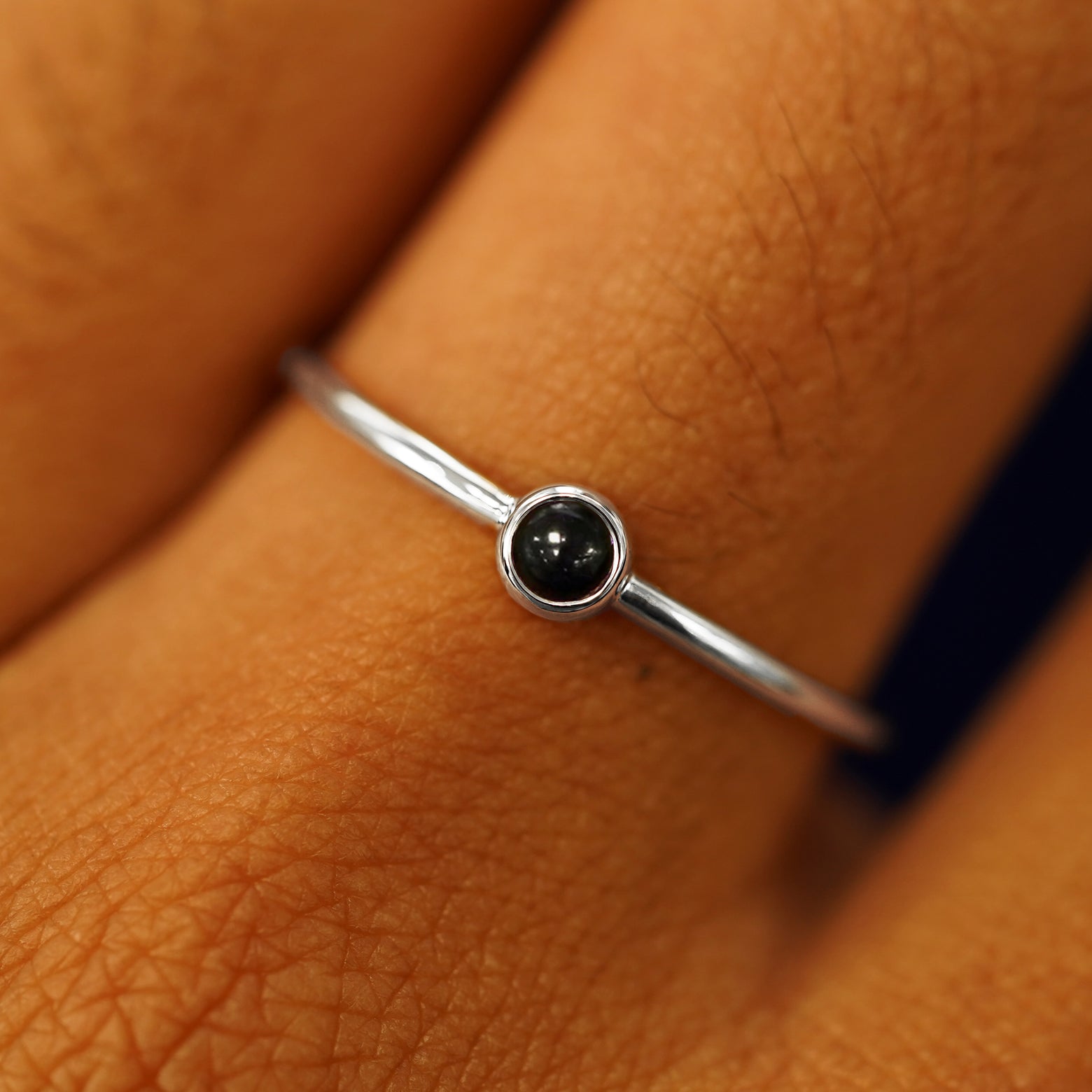 Close up view of a model's fingers wearing a 14k white gold Onyx Ring