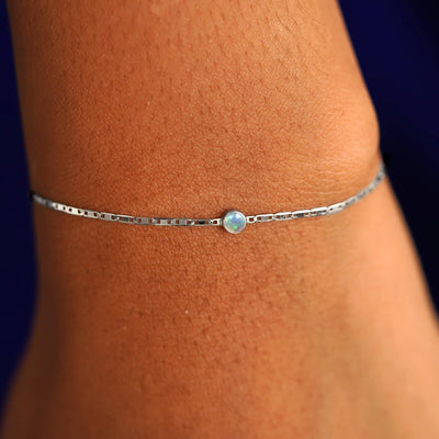 A model's wrist wearing a 14 karat white gold Opal Bracelet