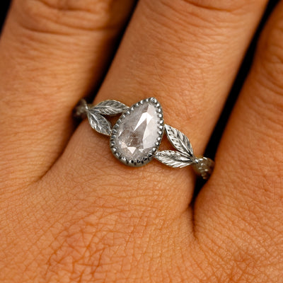 Close up view of a model's fingers wearing a 14k white gold Pear Salt and Pepper Diamond Leaves Ring