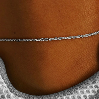 Close up view of a model's ankle wearing a white gold Rope Anklet