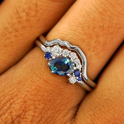Close up view of a model's fingers wearing a 14k white gold Sapphire and Diamond Cluster Ring Set