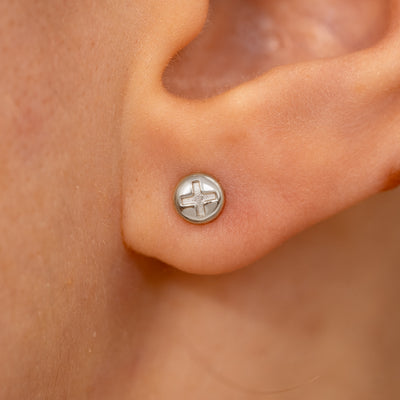 Close up view of a model's ear wearing a white gold Screw Earring