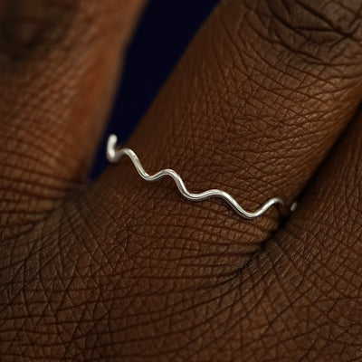 Close up view of a model's hand wearing a solid white gold Wave Ring