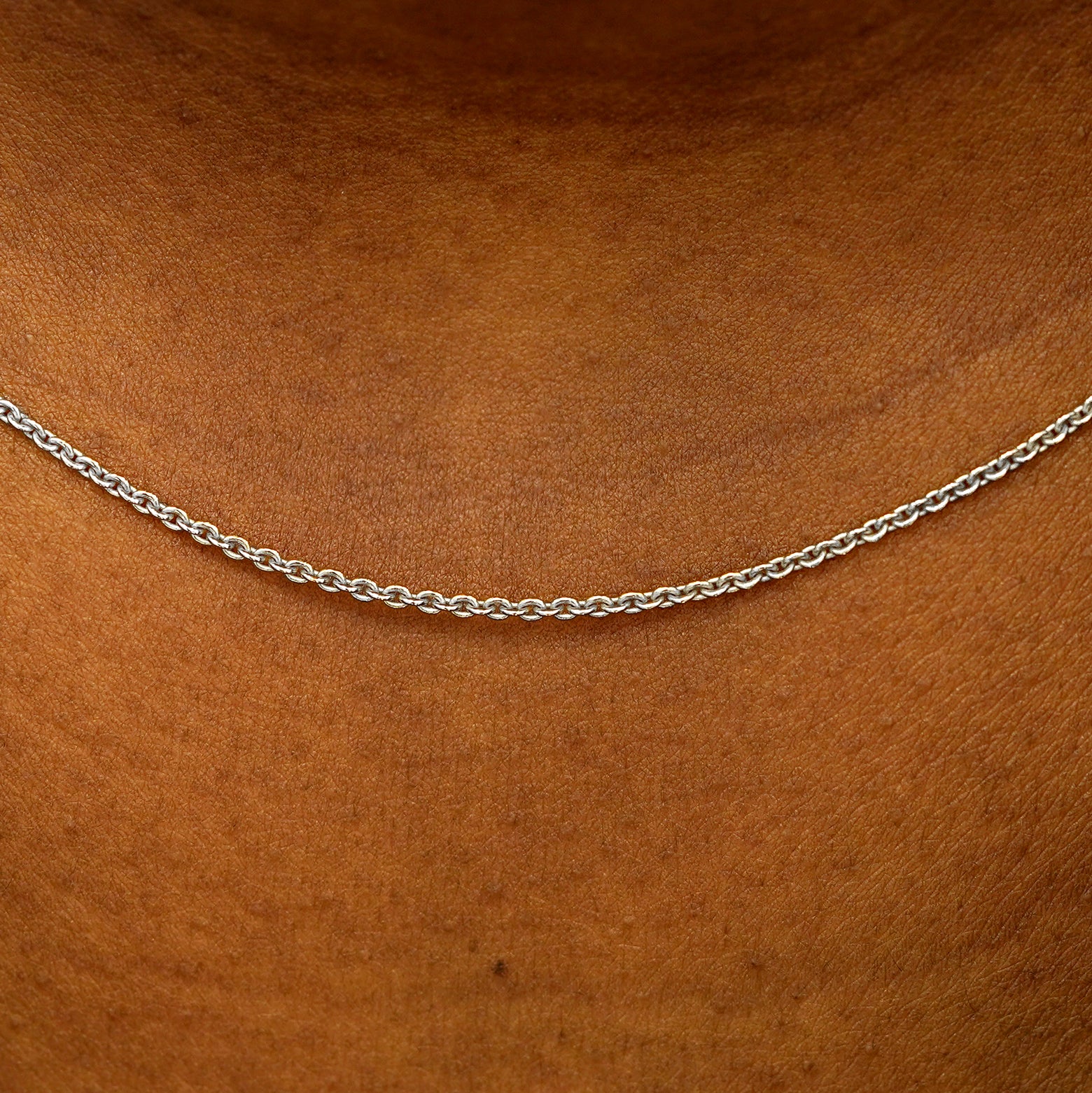 Close up view of a model's neck wearing a solid 14k white gold Thick Cable Chain