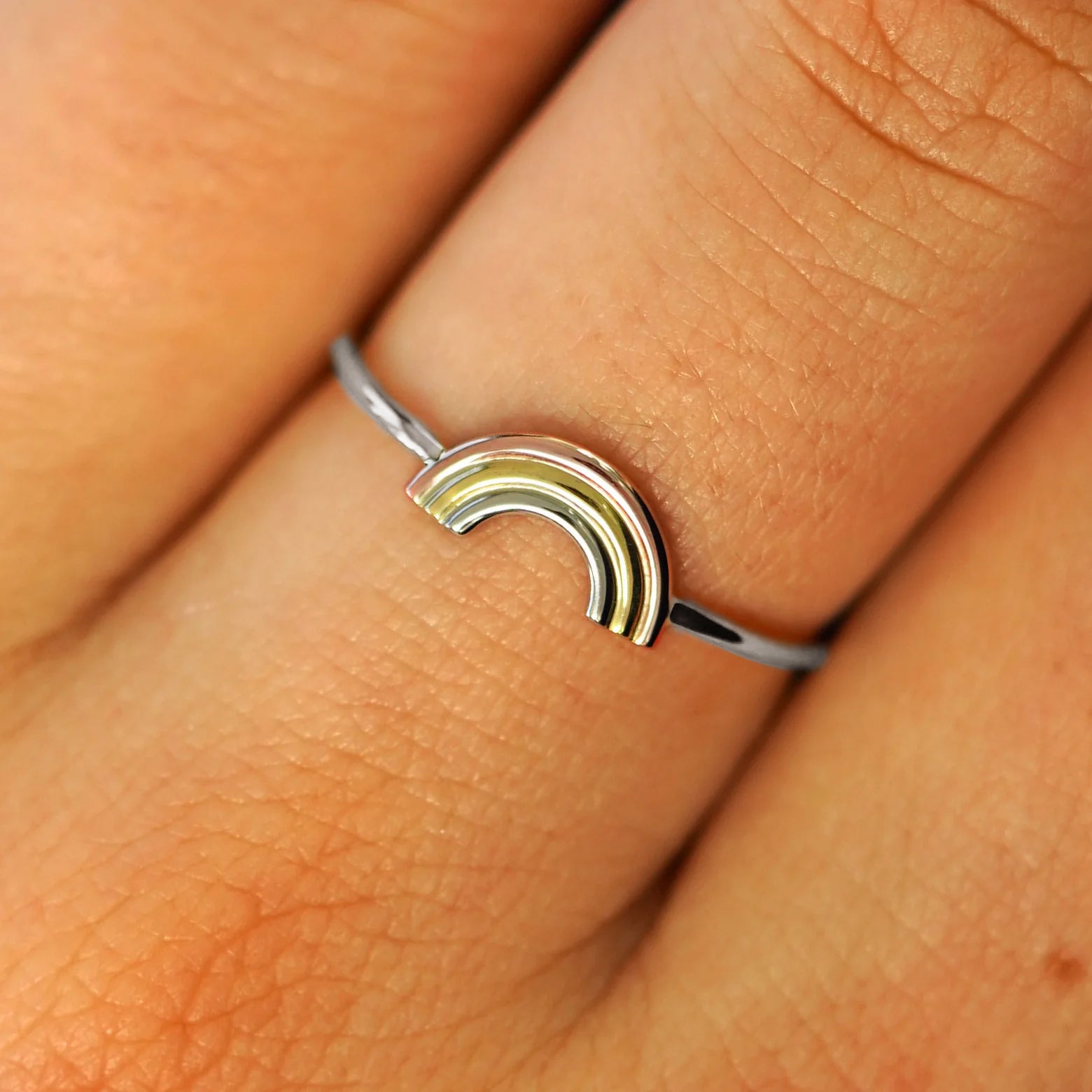 Close up view of a model's fingers wearing a solid white gold Rainbow Ring