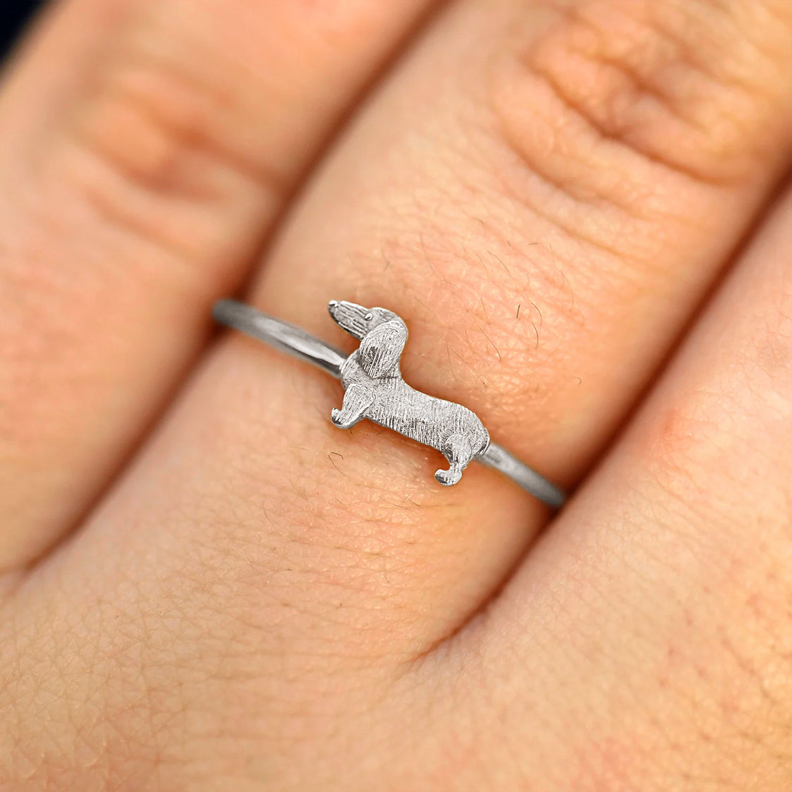 Close up view of a model's fingers wearing a 14k white gold Dog Ring