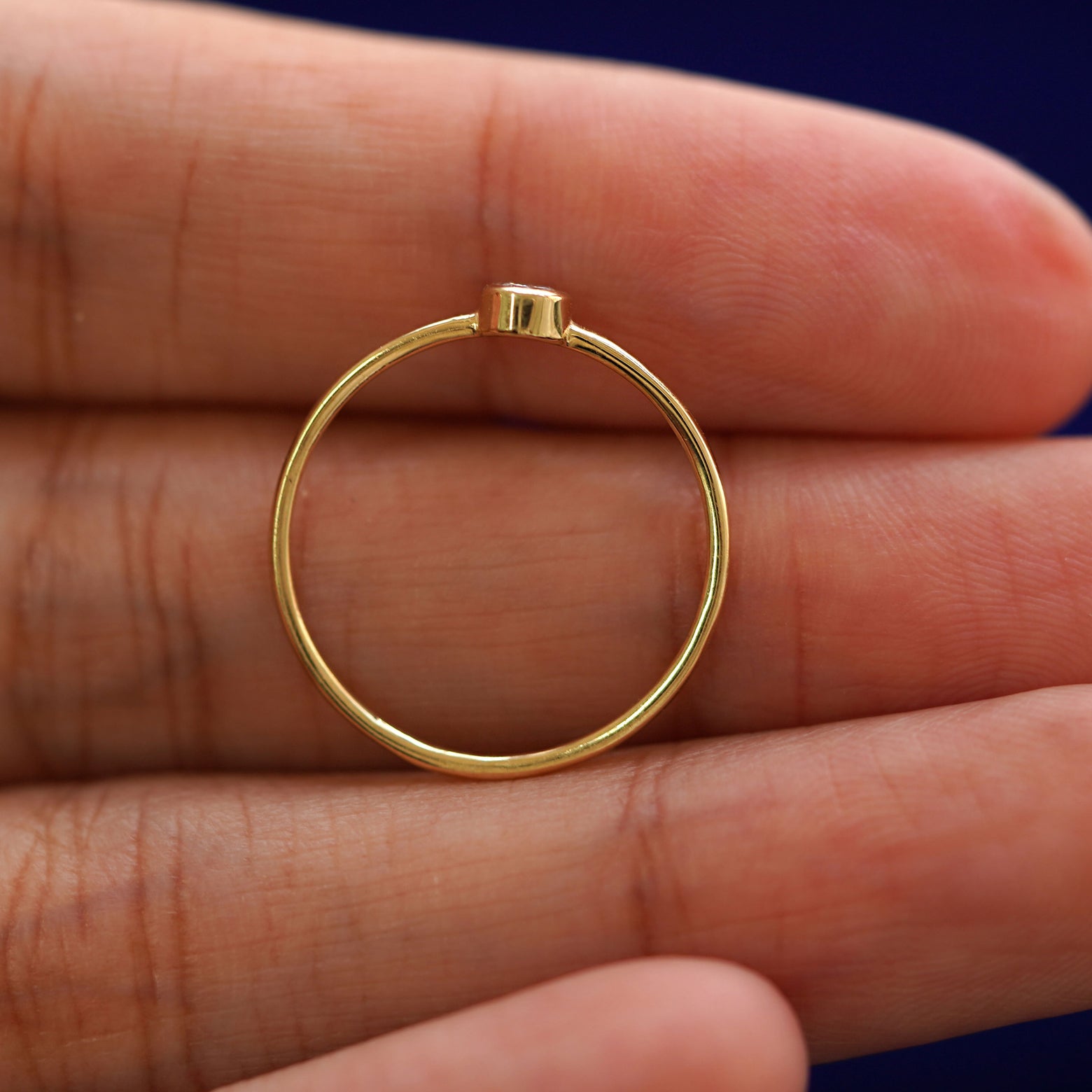 A yellow gold Yellow Diamond Ring in a model's palm showing the thickness of the band