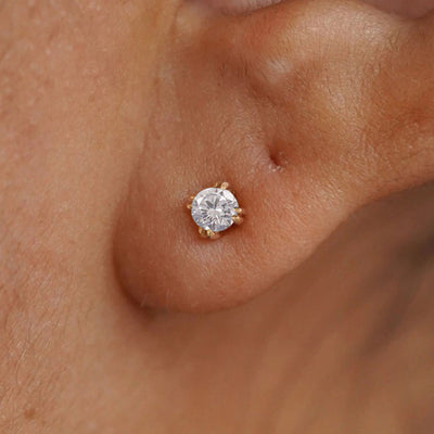 Close up view of a model's ear wearing a 14k yellow gold Diamond Earring