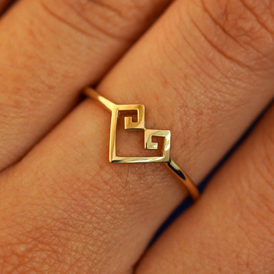 Close up view of a model's fingers wearing a 14k yellow gold Chere Heart Ring