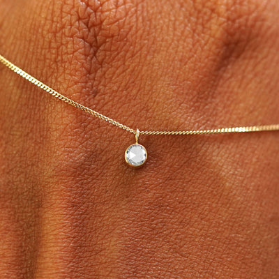 Close up view of a 14k yellow gold Rose Cut Diamond Necklace draped across the back of a model's hand