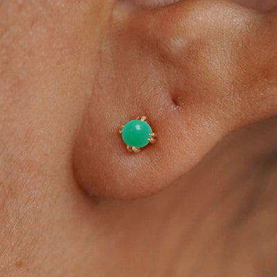 Close up view of a model's ear wearing a 14k yellow gold Green Jade Earring