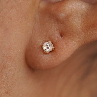 A model's ear wearing a 14k solid yellow gold Rose Cut Diamond Earring