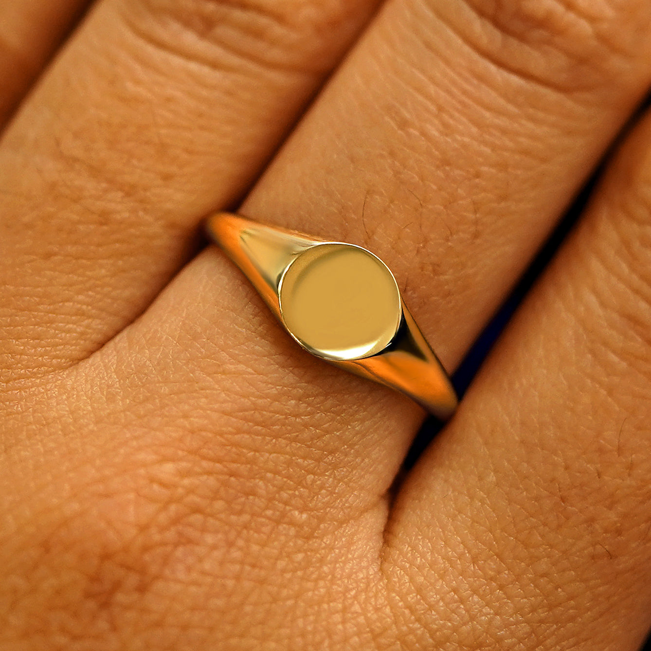 Close up view of a model's fingers wearing a 14k yellow gold Signet Ring
