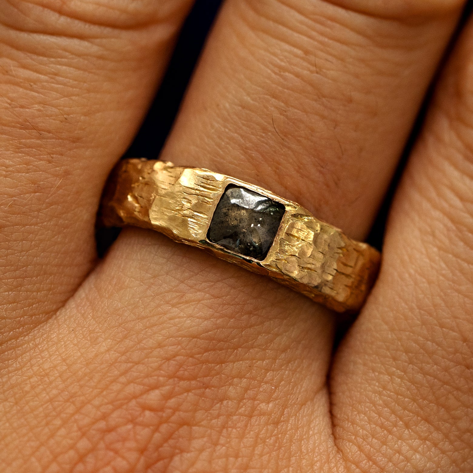 Close up view of a models fingers wearing a 14k yellow gold Square Diamond Organic Band