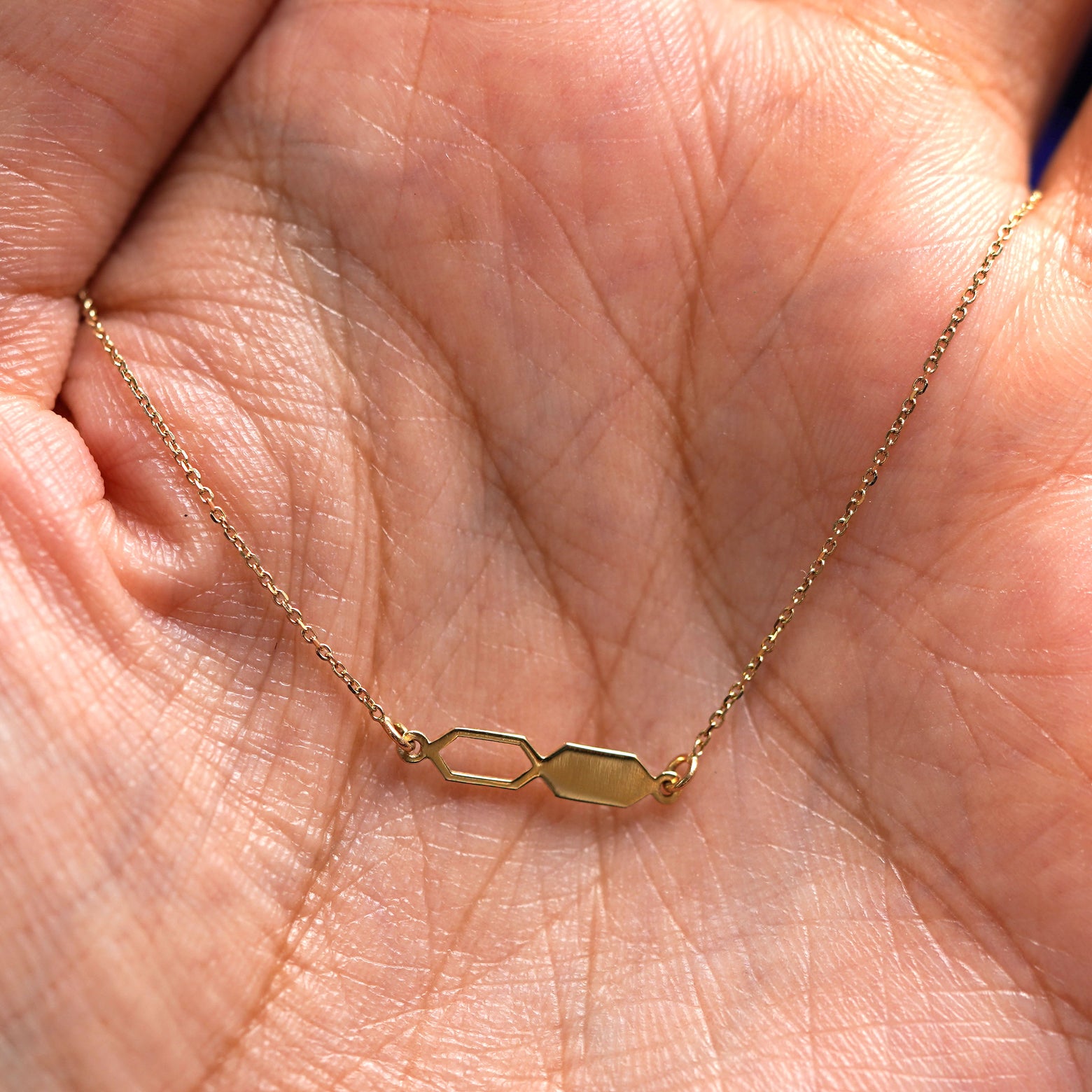 A yellow gold Tanlah Cable Bracelet draped on a model's palm