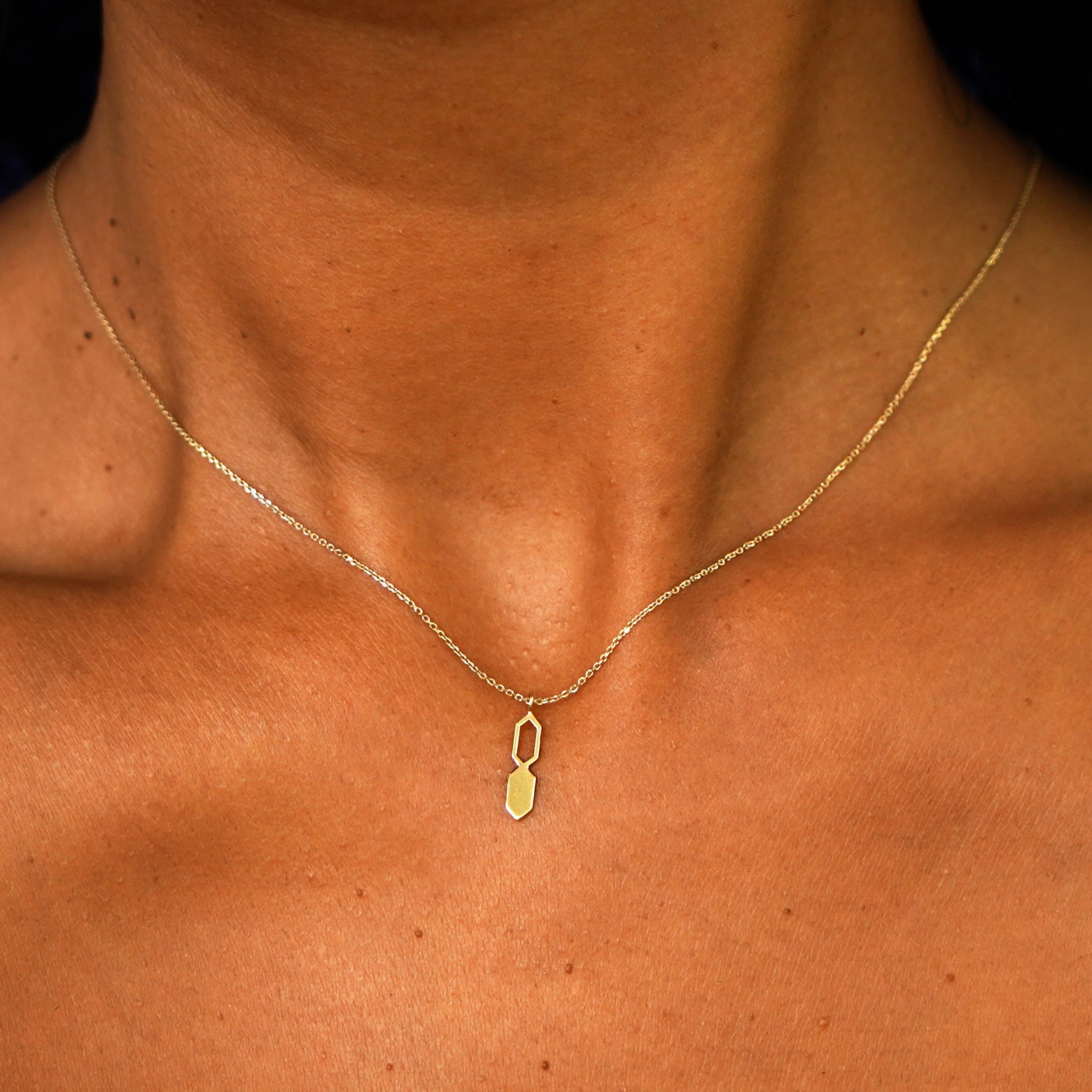 Close up view of a model's neck wearing a solid 14k yellow gold Tanlah Cable Necklace