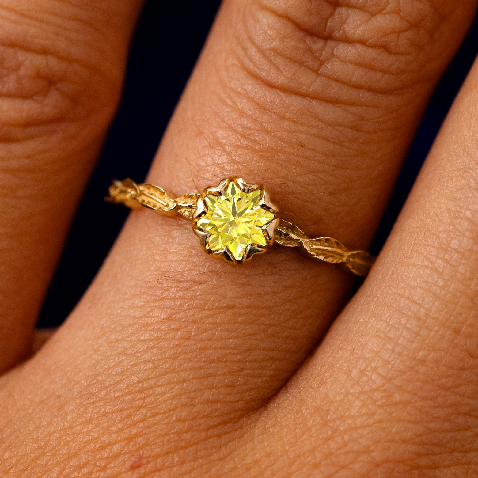 A solid 14k yellow gold Yellow Moissanite Leaf Ring on a model's finger