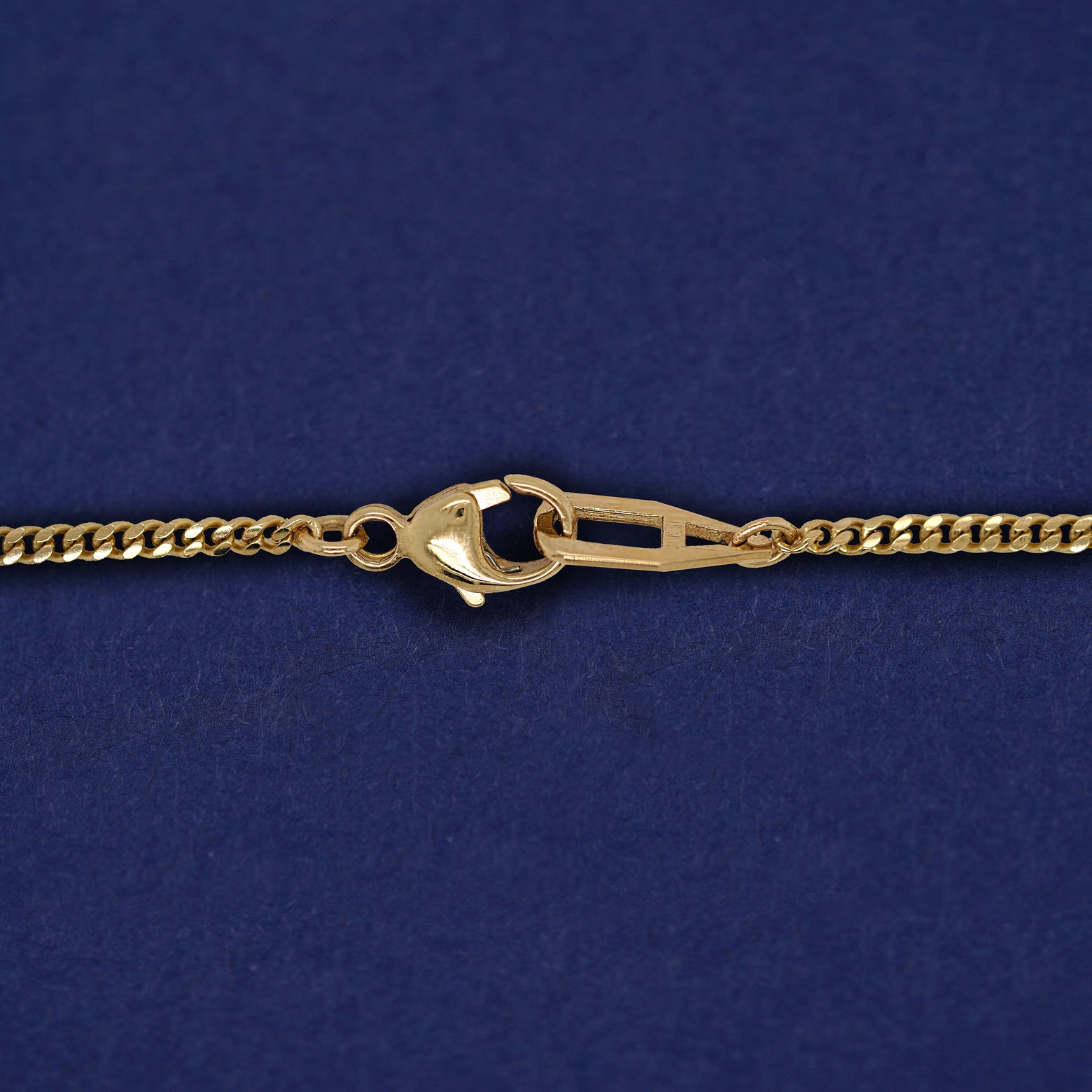 Close up view of a lobster lock and mini Miami chain on a yellow gold Enamel Heart Necklace