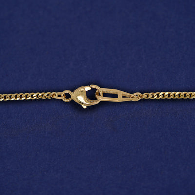 Close up view of a lobster lock and mini Miami chain on a yellow gold Enamel Heart Necklace