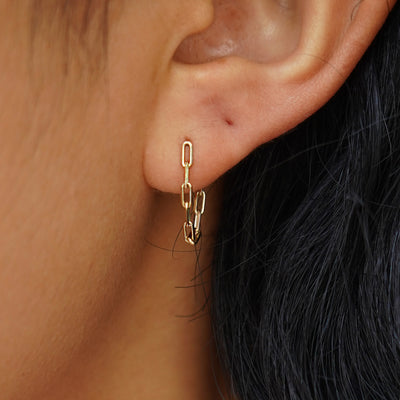 Close up view of a model's ear wearing a yellow gold Butch Chain Loop Earring