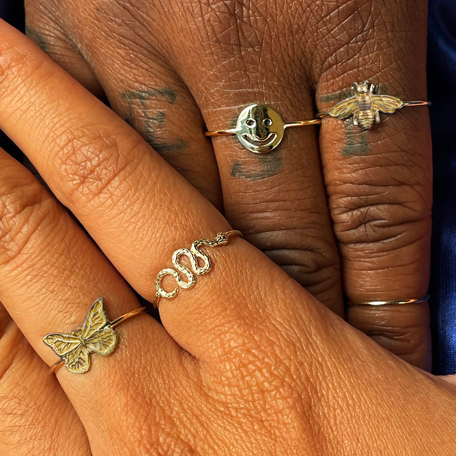 Two models holding hands while wearing various Automic Gold rings